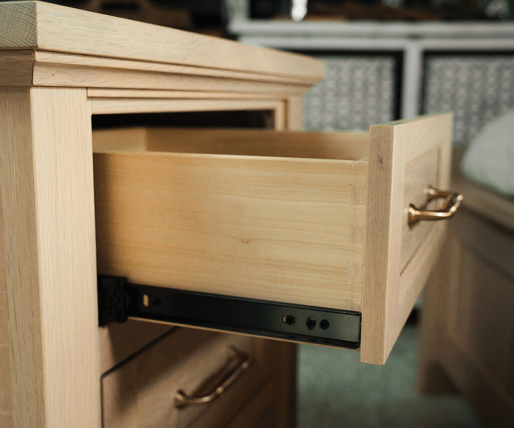 Dovetail drawer on slide pulled out for final fitting and inspection in Amish furniture.